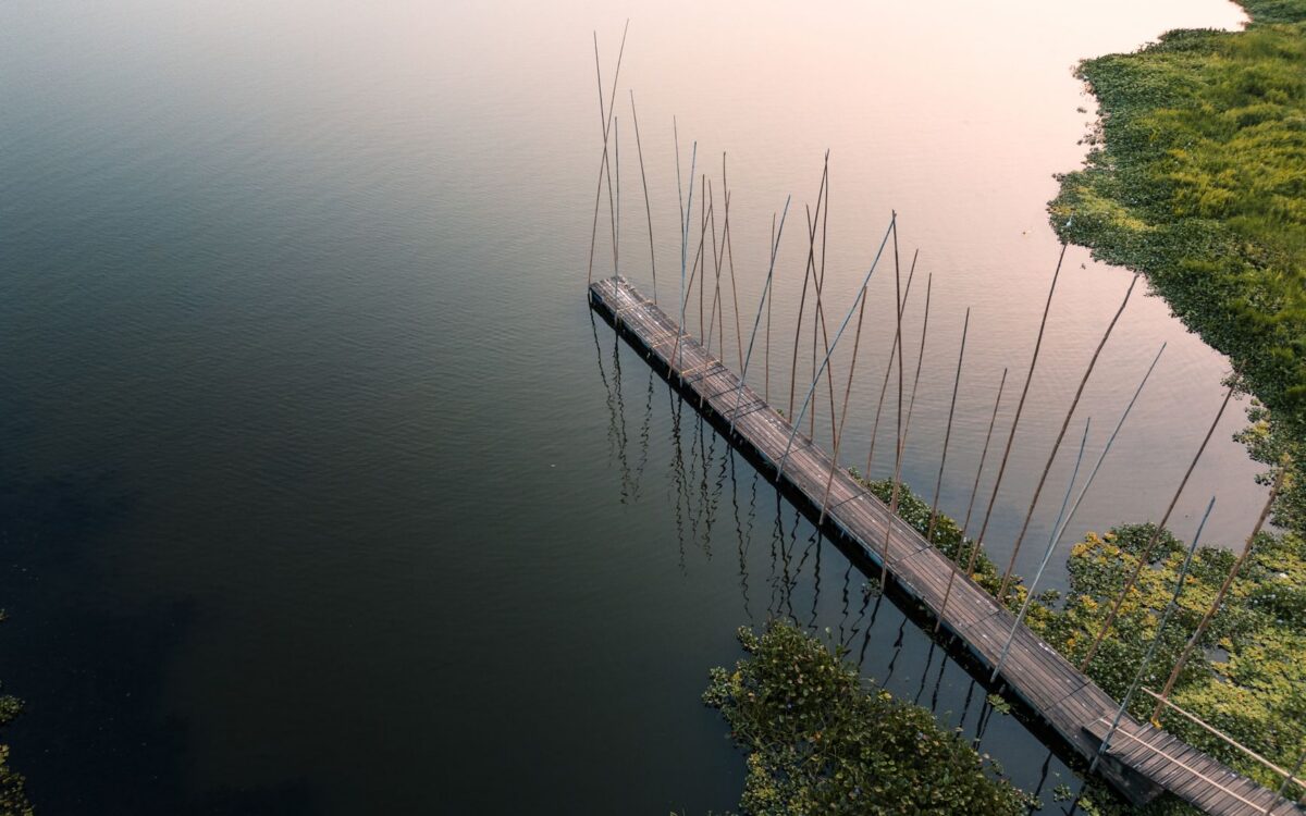 Hospedagem com lago para pesca esportiva em Lindóia, SP: vista tranquila da água com estrutura de pesca e natureza ao fundo