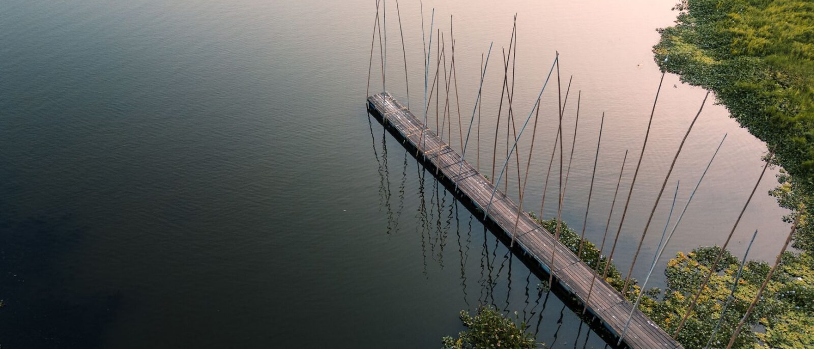 Hospedagem com lago para pesca esportiva em Lindóia, SP: vista tranquila da água com estrutura de pesca e natureza ao fundo