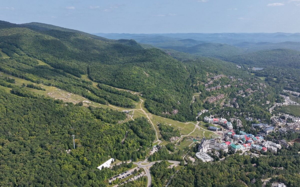 Vista panorâmica de Lindóia SP com montanhas, trilhas verdes e estrutura de pousada integrada à natureza