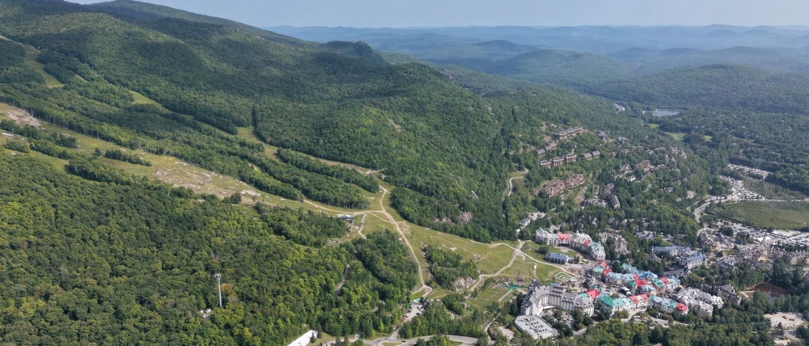Vista panorâmica de Lindóia SP com montanhas, trilhas verdes e estrutura de pousada integrada à natureza