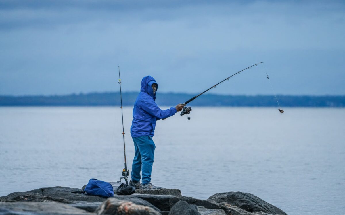Pescador iniciante praticando pesca esportiva em lago tranquilo de Lindóia SP ao amanhecer