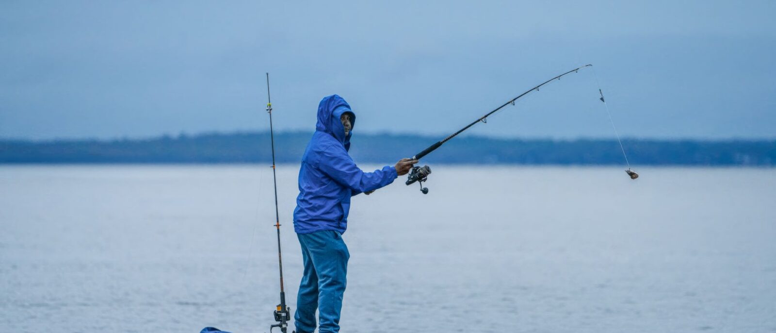 Pescador iniciante praticando pesca esportiva em lago tranquilo de Lindóia SP ao amanhecer