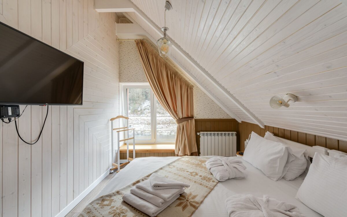 Quarto aconchegante no sótão com design moderno, acabamento em madeira e TV
